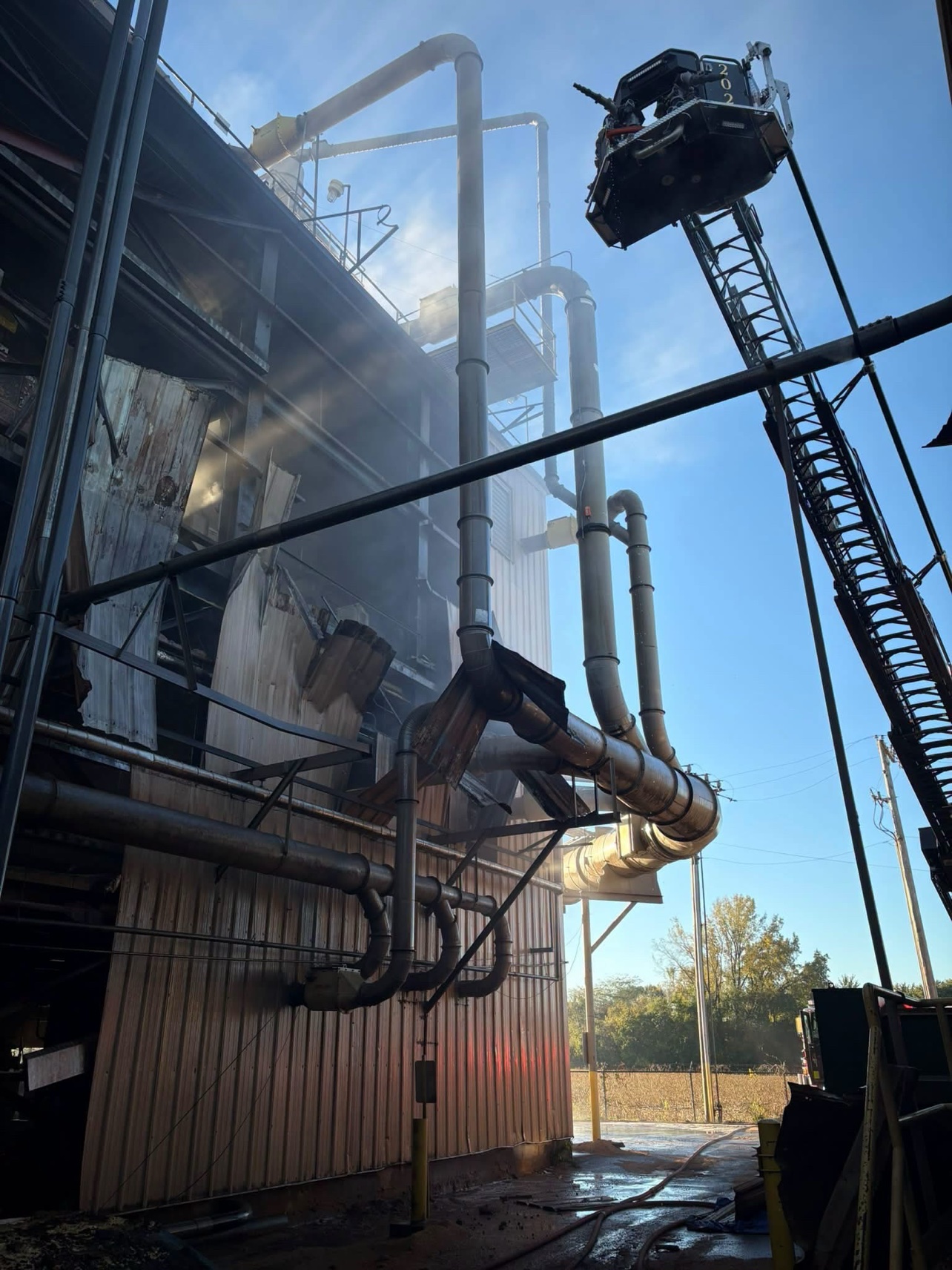 Crews in the aerial bucket check the damaged upper section of the plant.