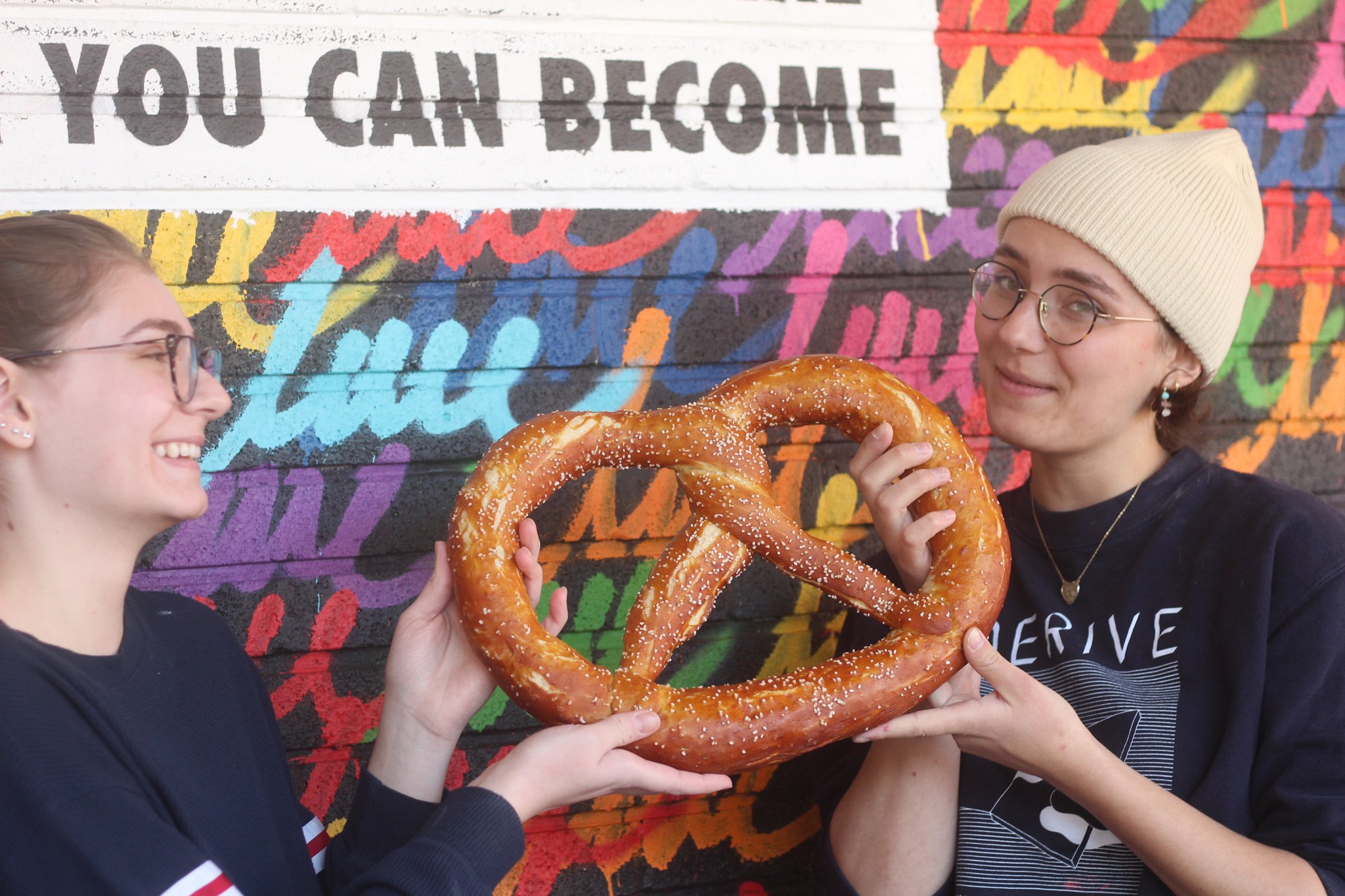 Two people holding the giant Pretzelsaurus pretzel at Brezel