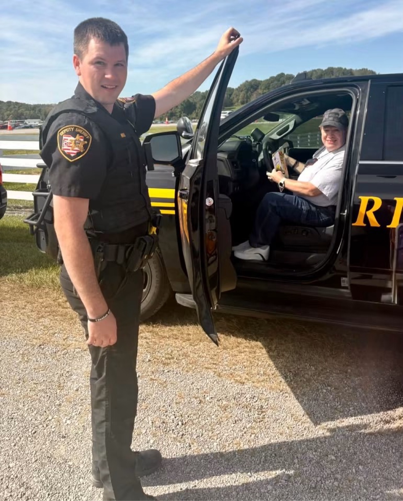 A Gallia County deputy holds the cruiser door open for a smiling festivalgoer at the Bob Evans Farm Festival