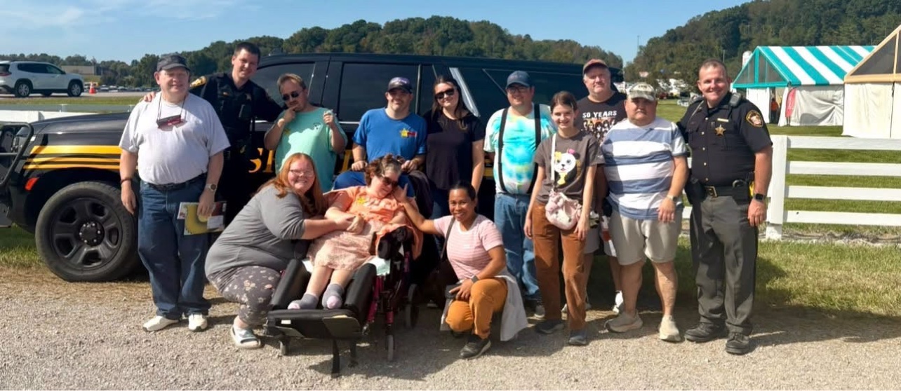 Gallia County deputies pose with festivalgoers in front of a sheriff's SUV