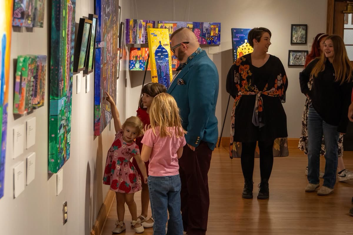 Artist Michael Kirk shares a laugh with a visitor during the opening reception.