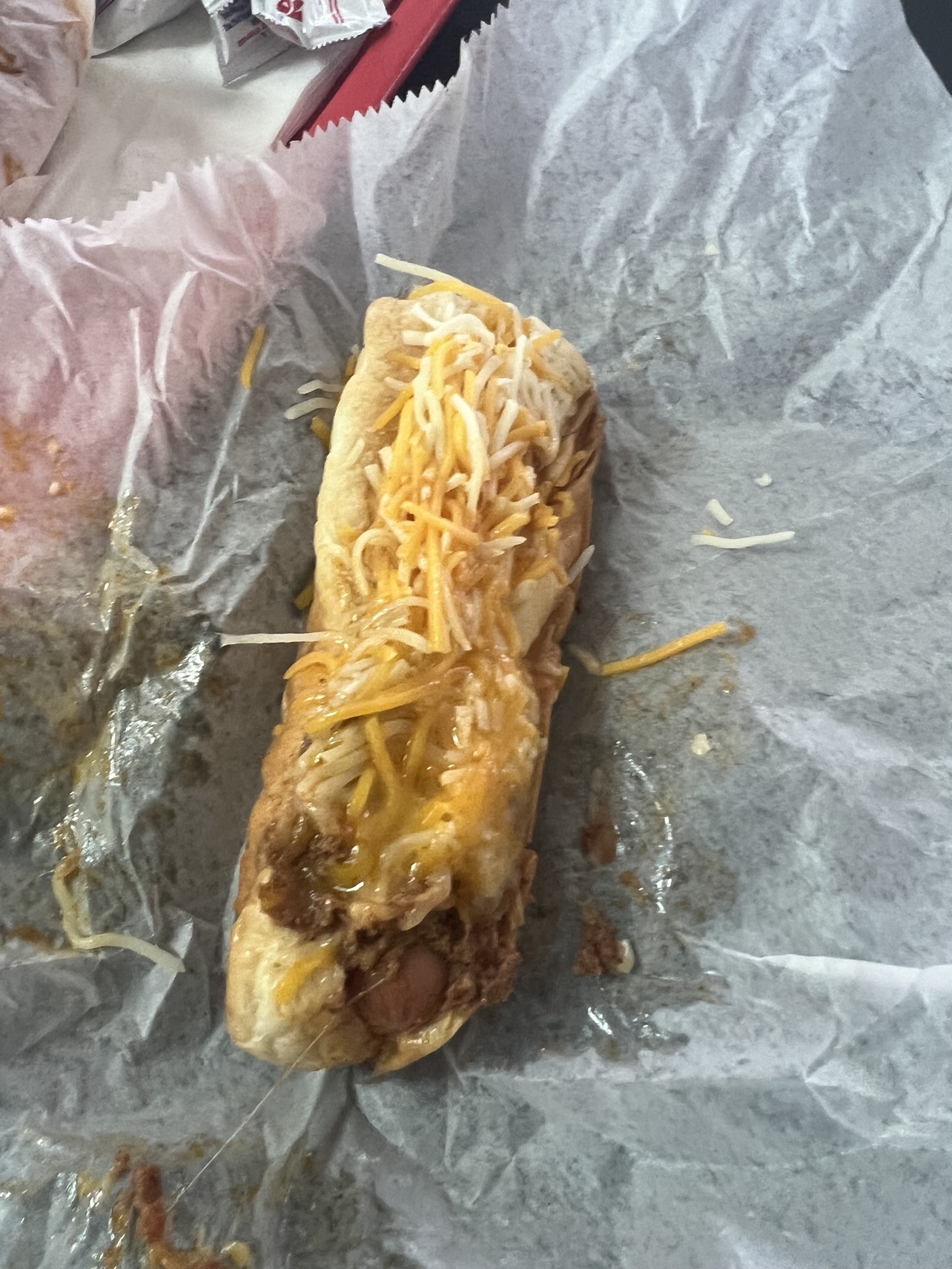 Close-up of a coney with sauce and shredded cheese at Tony's Coney's