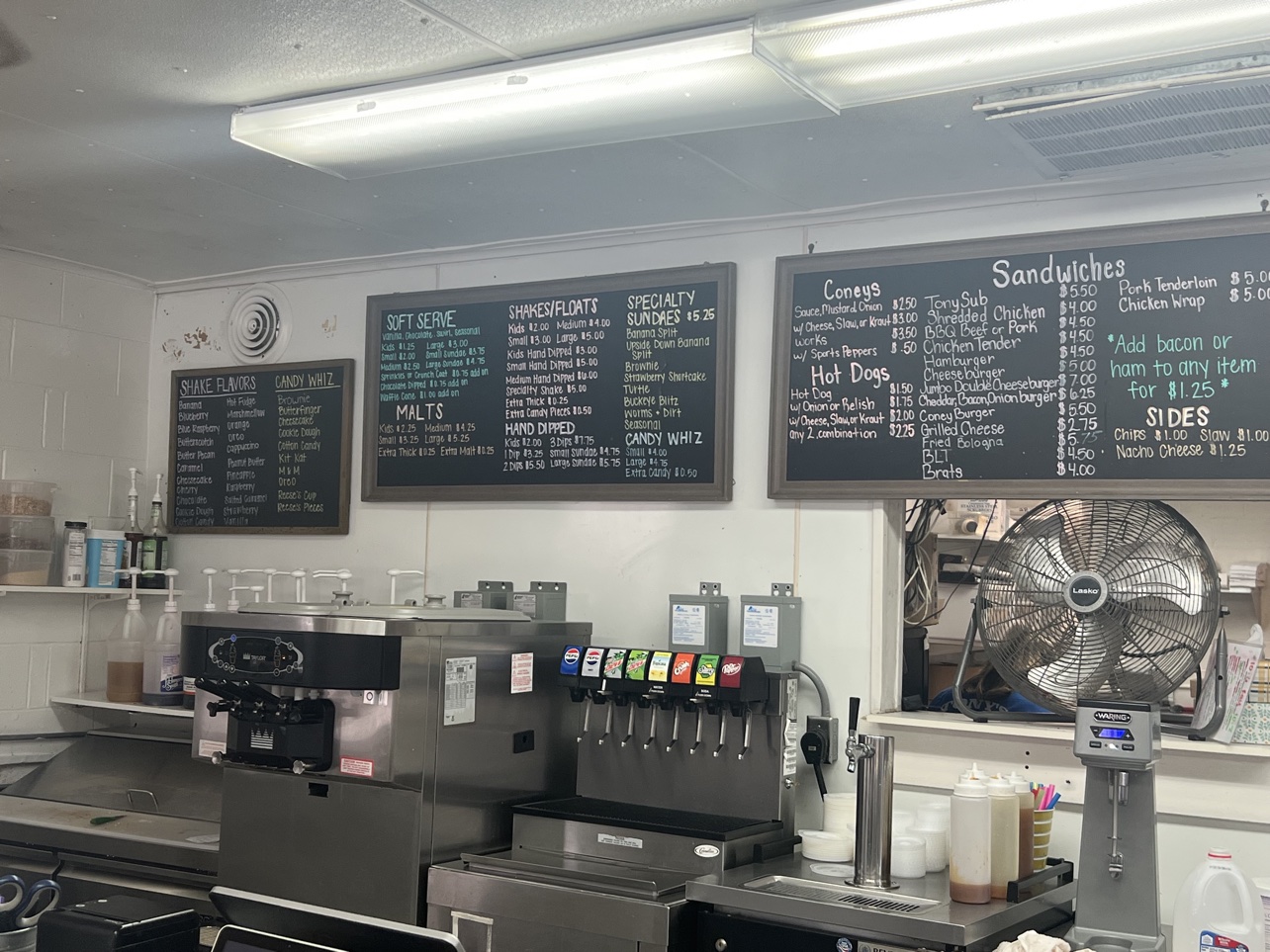 Chalkboard menus showing coneys sandwiches and ice cream prices at Tony's Coney's