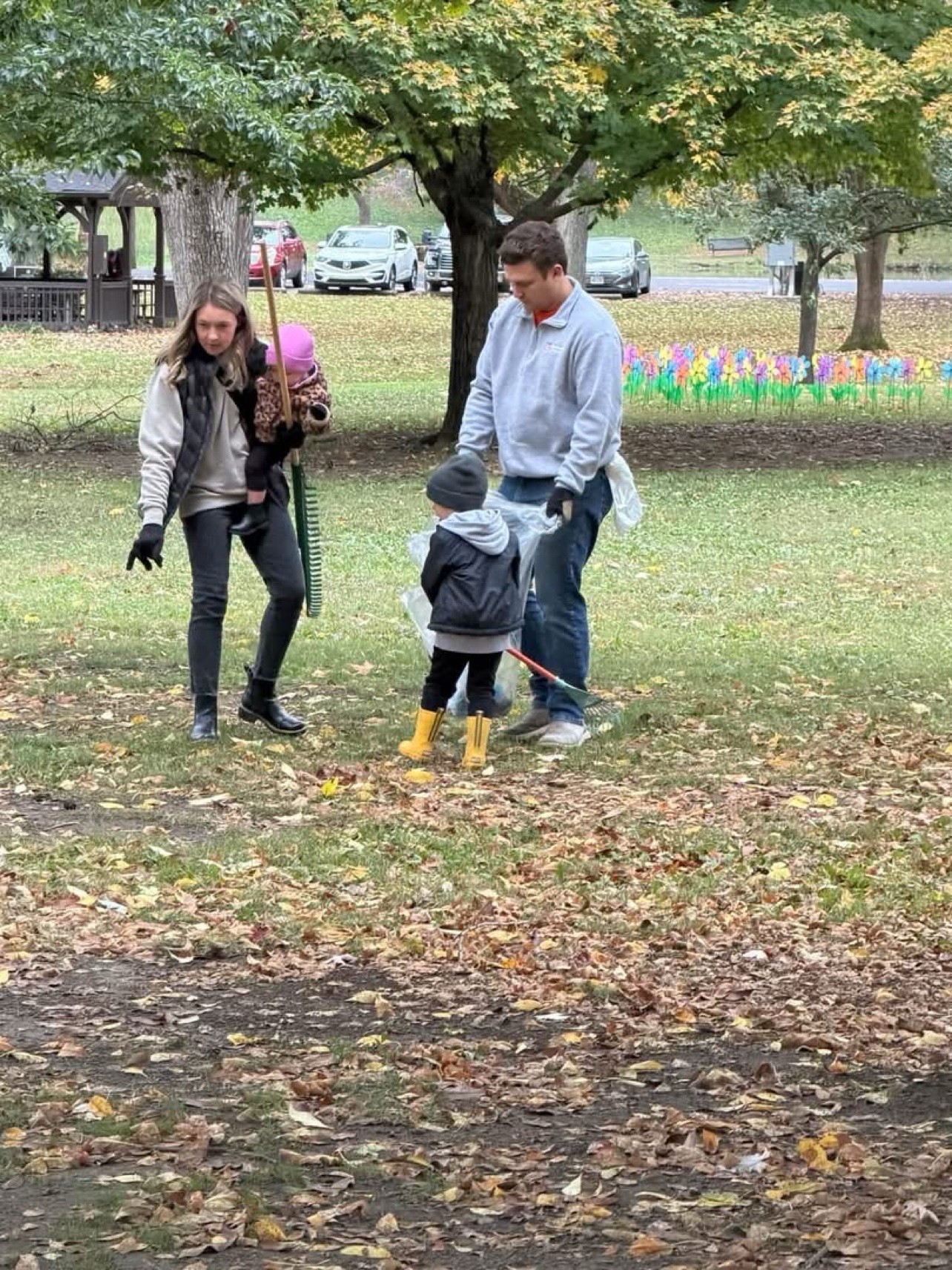 A family rakes leaves during the Yoctangee Park cleanup