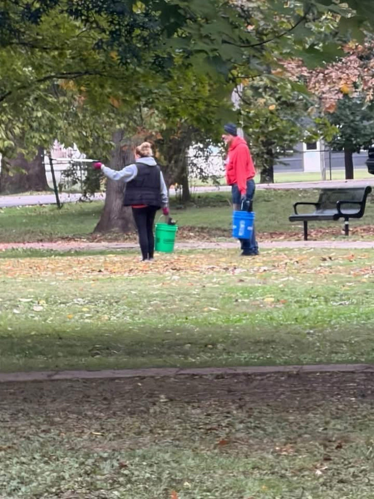 Two volunteers carry buckets during the cleanup